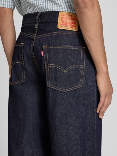 Männermodel trägt Wide Leg Baggy Jeans aus reiner Baumwolle Modell 'EXTRA BAGGY' von Levi's®, dunkles Denim, Kontrastnähte, Nahaufnahme Rückansicht, Herren Baggy Jeans von Levi's®.