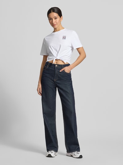 Frauenmodel trägt T-Shirt mit Knotendetail und Rundhalsausschnitt von Rich & Royal, weiße Baumwolle, Regular Fit, Vorderansicht Ganzkörperansicht.