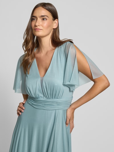Frauenmodel trägt Schimmerndes Maxikleid mit V-Ausschnitt und Taillenband von Christian Berg Cocktail aus Mesh in A-Linie, Nahaufnahme Oberkörper.