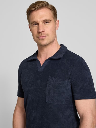 Męski model nosi Relaxed Fit Poloshirt mit V-Ausschnitt von Lindbergh, mieszanka bawełny, frota, brustasza, długość tyłu w rozmiarze M: 76 cm, ciemnoniebieski kolor, faktura froty, nahaufnahme górnej części ciała.