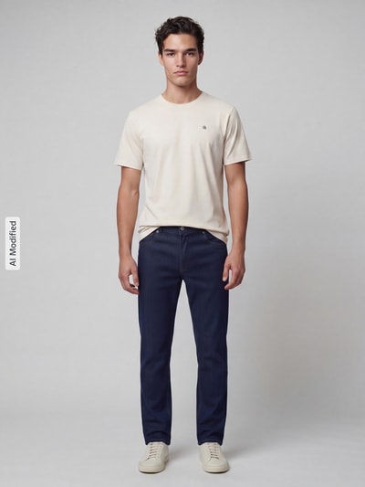 Männermodel trägt T-Shirt mit Label-Stitching und Rundhalsausschnitt von Scotch & Soda, cremefarben, Regular Fit, ganzkörperansicht von vorne.