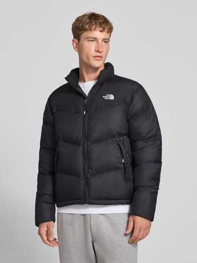 Männermodel trägt schwarze Regular Fit Jacke in Stepp-Optik Modell 'SAIKURU' von The North Face, Logo-Stitching, Nahaufnahme Oberkörper.