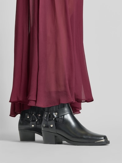 Vrouwenmodel draagt Biker Boots uit echt leer van Anine Bing, zwart met zilverkleurige studs, blokhak, elastisch inzetstuk met siernaden, detailopname onderbeen.