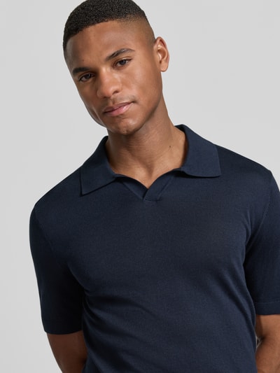 Männermodel trägt Slim Fit Poloshirt aus Lyocell-Baumwoll-Mix von OLYMP Level Five in Dunkelblau, Nahaufnahme Oberkörper. Herren Poloshirt, Polokragen, Kurzärmelig, Rückenlänge bei Größe M: 68 cm.