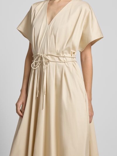 Frauenmodel trägt Cocktailkleid mit V-Ausschnitt und Schnürung von Christian Berg Cocktail, Beige, A-Linie, Baumwoll-Elasthan, Nahaufnahme Oberkörper.