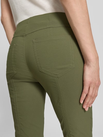 Frauenmodel trägt Caprihose aus Viskose-Mix Modell 'Igor3' von STEHMANN, Slim-Fit, grüner Stoff mit Stretch-Anteil, Detailaufnahme Rückansicht. Damen Caprihose, elastischer Bund, Bundweite 38 cm, Innenbeinlänge 69 cm bei Größe 36.