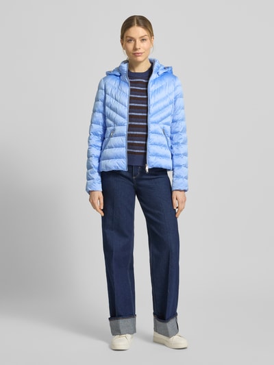 Frauenmodel trägt Taillierte Steppjacke mit Zweiwege-Reißverschluss Modell 'ANYA' von Beaumont Amsterdam, hellblau, glatte Oberfläche, Streifenpullover und Jeans, Ganzkörperansicht von vorne. Damenjacke mit Kapuze, Rückenlänge 55 cm, Schulterbreite 38 cm, Brustweite 48 cm, Ärmellänge 61 cm.