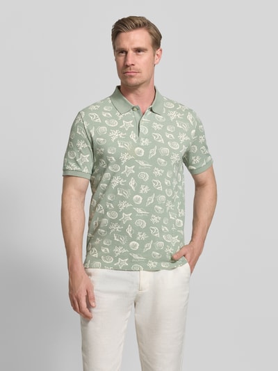 Männermodel trägt Regular Fit Poloshirt mit Allover-Motiv-Print von Gant aus Reine Baumwolle, grün gemustert, Polokragen, Kurzärmelig, Ganzkörperansicht von vorne. Rückenlänge bei Größe M: 68 cm.