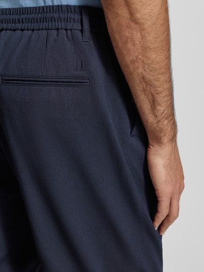 Männermodel trägt Stoffhose mit elastischem Bund Modell 'Como' von Les Deux in Dunkelblau, Material-Mix, Detailaufnahme Rückansicht.
