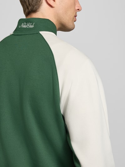 Männermodel trägt Relaxed Fit Sweatshirt aus Baumwoll-Mix von Nike in Grün und Creme, glatte Textur, Herren Sweatshirt, Ganzkörperansicht Rückansicht.