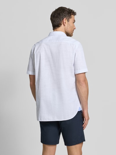 Męski model nosi Regular Fit Freizeithemd mit Button-Down-Kragen od Christian Berg Men, bawełna, krój regular fit, biała koszula z kieszenią na piersi, długość tyłu w rozmiarze M 78 cm, szerokość w rozmiarze M 44 cm, długość rękawa w rozmiarze M 26 cm, tekstura delikatna, krótkie rękawy, widok całej sylwetki z tyłu.