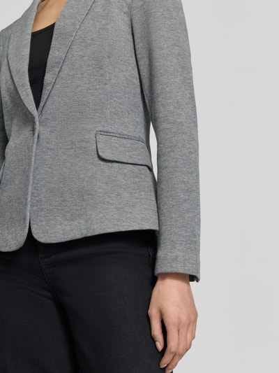 Vrouwenmodel draagt slim fit kortblazer met katoen-aandeel model 'JULIA' van VERO MODA in lichtgrijs, detailopname van het bovenlichaam.