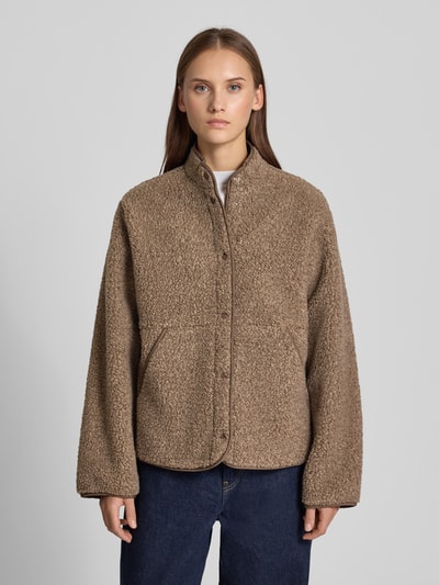 Vrouwenmodel draagt Jacke aus Teddyfell Modell 'VERA' van JJXX in bruin met rechte pasvorm, opstaande kraag, steekzakken, drukknoopsluiting, ruglengte maat S 65 cm, schouderbreedte 42 cm, borstwijdte 56 cm, mouwlengte 60 cm, teddybonttextuur, Ganzkörperansicht van voren.