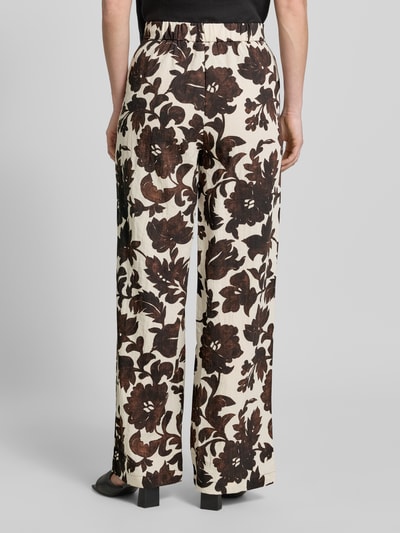 Frauenmodel trägt Stoffhose aus Viskose-Mix mit Eingrifftaschen Modell 'KARINA' von KARINA, florales Muster, Wide-Leg-Fit, Ganzkörperansicht Rückansicht. Bundweite bei Größe S: 39 cm, Innenbeinlänge bei Größe S: 77 cm, Haken- und Reißverschluss.