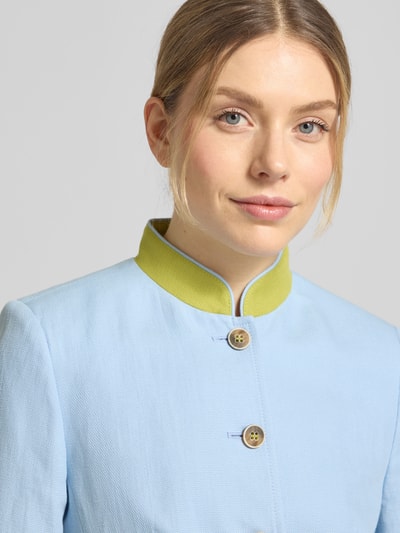 Vrouwenmodel draagt Slim Fit Blazer aus Leinen-Baumwoll-Mix van WHITE LABEL, lichtblauw met groene opstaande kraag, knoopsluiting, opgestikte zakken, borstwijdte 44 cm bij maat 36, linnen katoenmix, close-up bovenlichaam.