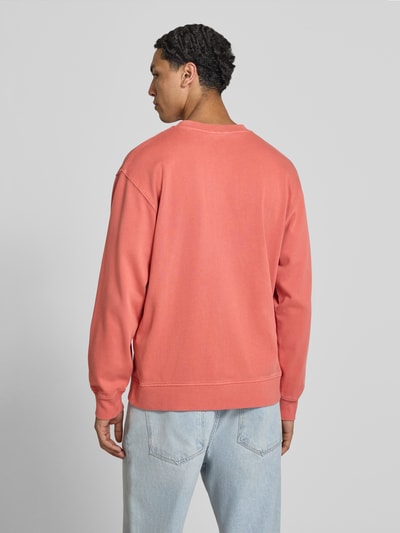 Männermodel trägt Regular Fit Sweatshirt aus reiner Baumwolle Modell 'JOHN CREW' von Pepe Jeans in Koralle, Ganzkörperansicht Rückansicht, Herren Sweatshirt.