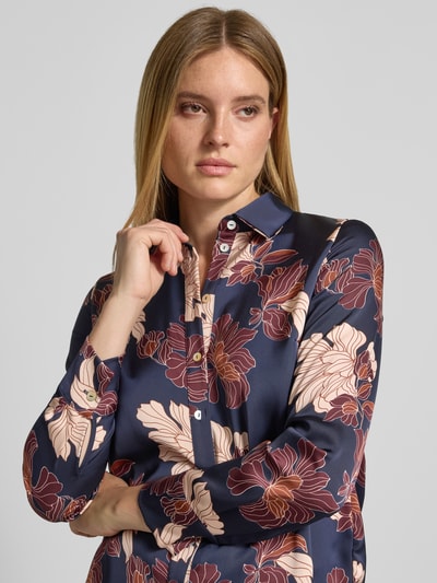 Vrouwenmodel draagt Regular Fit Hemdbluse aus Satin van Christian Berg Woman Selection, donkerblauw met bloemendessin, satijn, blousekraag, doorknoopsluiting, lange mouwen, detailopname bovenlichaam.