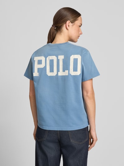 Frauenmodel trägt Relaxed Fit T-Shirts aus reiner Baumwolle von Polo Ralph Lauren in Hellblau mit weißem Schriftzug, Damen T-Shirt, Ganzkörperansicht Rückansicht.