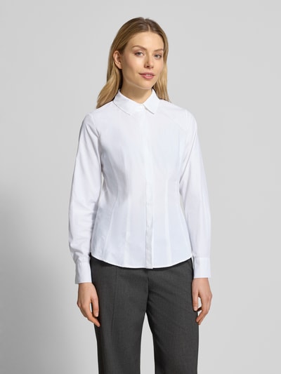 Modelka kobieta nosi Hemdbluse mit Knopfleiste Modell 'NETTI' od Soyaconcept, biały materiał z bawełną, krój slim fit, widok całej sylwetki z przodu.