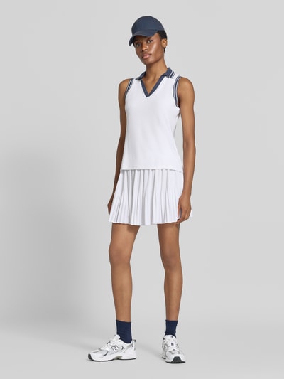 Kobiece model nosi Regular Fit koszulkę polo z mieszanki lyocellu Model 'Isaac' od VARLEY, kolor biały, kołnierzyk polo, krój bez rękawów, długość tyłu w rozmiarze S: 61 cm; widok całej sylwetki z przodu.