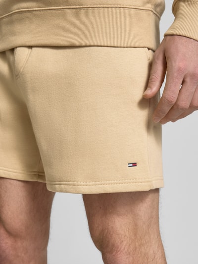 Männermodel trägt Regular Fit Shorts aus katoenmix van Tommy Jeans, look: effen, logodetail, boord met tunnelkoord, steek- en achterzak, sweatmateriaal, detailaufnahme rechterbovenbeen