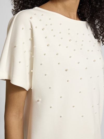 Vrouwenmodel draagt T-shirt met ronde hals en parels van Christian Berg Woman, materiaalmix met modal, relaxed fit, detailopname.