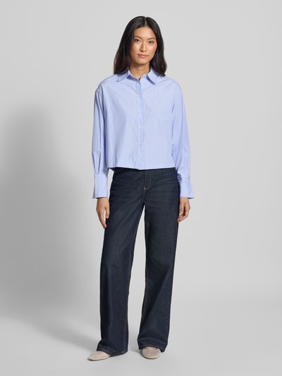 Frauenmodel trägt Relaxed Fit Hemdbluse mit Strasssteinbesatz von MANGO, hellblau mit dezenten Streifen, Material-Mix, Knopfleiste, Baumwoll-Anteil, weite blaue Hose, Ganzkörperansicht von vorne.