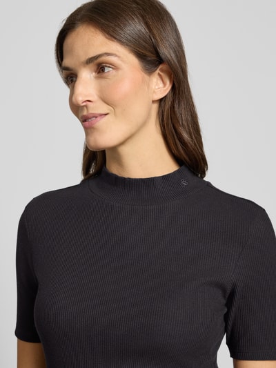 Vrouwenmodel draagt T-Shirt met geribde opstaande kraag van Scotch & Soda, zwart, katoenen-elastaanmix, regular fit, close-up bovenlichaam.
