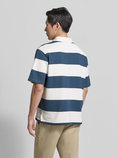 Männermodel trägt Relaxed Fit Poloshirt im Allover-Look von MCNEAL, Baumwoll-Mix, breite blaue und weiße Streifen, Rückenansicht, Ganzkörperansicht Rückansicht.