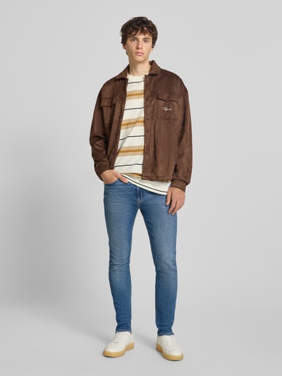 Männermodel trägt Slim Fit Jeans aus Baumwoll-Mix Modell 'Zane' von HUGO Blue in Hellblau, schmal geschnitten, Ganzkörperansicht von vorne.