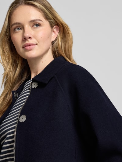 Frauenmodel trägt Regular Fit Jacke mit Umlegekragen von Blonde No. 8, dunkelblau, glatte Textur, Nahaufnahme Oberkörper.