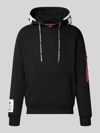 Produktfoto, Regular Fit Hoodie aus Baumwoll-Mix mit Label-Patch von Alpha Industries, schwarze Kapuze, Känguru-Tasche, Ärmel-Tasche, weißer Print, Struktur glatt