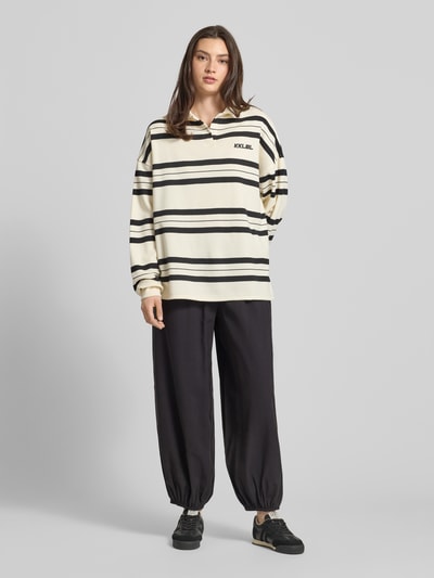 Frauenmodel trägt Loose Fit Weite Hose mit elastischem Bund Modell 'SCARLY' von Only, unifarben, elastischer Beinabschluss, Eingrifftaschen, Ganzkörperansicht von vorne.
