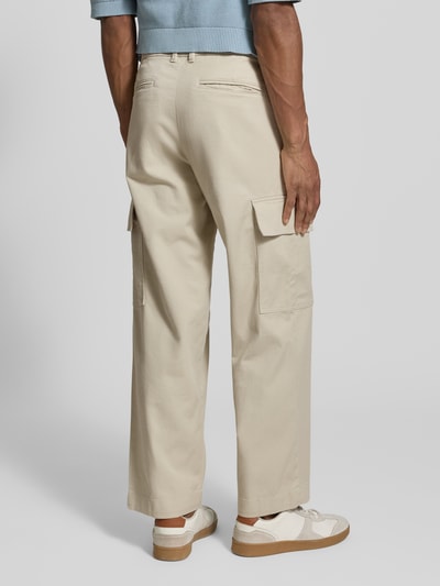 Mężczyzna nosi Loose Fit Cargohose aus Bio-Baumwoll-Mix Modell '220-LOOSE MILES COMFORT' od SELECTED HOMME, jednolity beż, luźny krój, średni stan, kieszenie boczne i tylne, bawełniany materiał, widok całej sylwetki z tyłu.