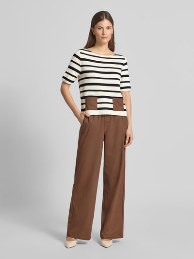 Kobiece modelka nosi Strickshirt mit aufgesetzten Taschen od Oui, mieszanka materiałów z dodatkiem streczu, krój regular fit, okrągły dekolt, nakładane kieszenie, detal z logo, długość tyłu w rozmiarze 36: 52 cm, długość rękawów w rozmiarze 36: 27 cm, biało-czarne paski z brązowymi detalami, widok całej sylwetki z przodu.