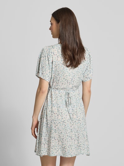Frauenmodel trägt Minikleid aus reiner Viskose Modell 'EVIDA' von Only mit Allover-Muster, hellen Farben, Rückansicht, Ganzkörperansicht.