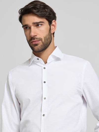 Männermodel trägt weißes Super Slim Fit Business-Hemd mit Kentkragen von Jake*s, glatter Stoff, silberne Knöpfe, Nahaufnahme Oberkörper.