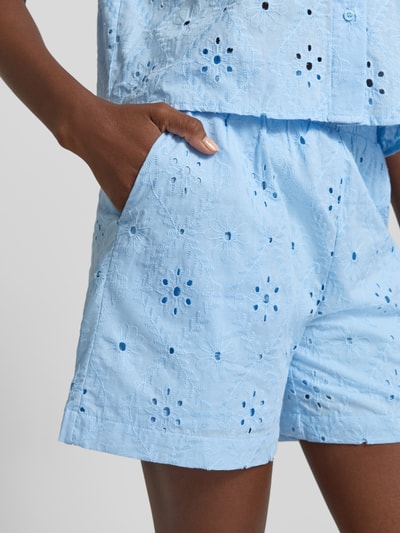 Frauenmodel trägt Regular Fit Shorts aus reiner Baumwolle Modell 'ELIZA' von Vero Moda in hellblau mit Lochstickerei, Nahaufnahme Oberschenkel.