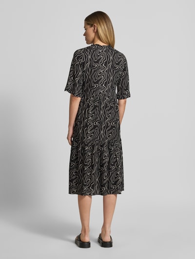Frauenmodel trägt Ausgestelltes Maxikleid aus reiner Viskose Modell 'EASY JOY' von Vero Moda mit Allover-Muster, Rückansicht.