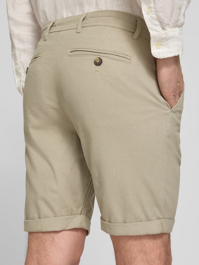 Männermodel trägt Slim Fit Chinoshorts aus Baumwoll-Mix Modell 'LUTON' von SELECTED HOMME, unifarben, feine Webstruktur, Ganzkörperansicht Rückansicht.