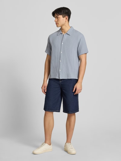 Männermodel trägt Regular Fit Freizeithemd mit Kentkragen von Jack & Jones, reine Baumwolle, hellblau, Knopfleiste, Halbarm, Ganzkörperansicht von vorne.