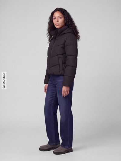 Frauenmodel trägt Regular Fit Steppjacke mit Kapuze Modell 'CLAIR' von ONLY, schwarze Farbe, glatte Oberfläche, Ganzkörperansicht von vorne, Damen Steppjacke von ONLY, KI-modifiziertes Bild.