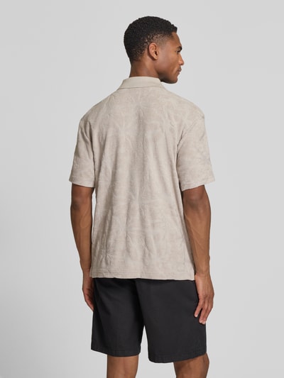 Männermodel trägt Regular Fit Poloshirt aus Baumwoll-Mix Modell 'PE_FLOWER' von BOSS Orange, Struktur, Optik:Allover-Muster, Ganzkörperansicht Rückansicht.