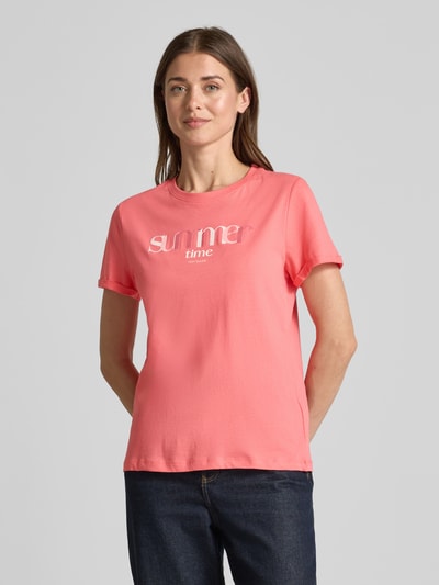 Modelka kobieca ma na sobie Regular Fit T-Shirt aus reiner Baumwolle od Tom Tailor, jednolity kolor, nadruk z napisem, jersey, krótki rękaw, widok na cały przód.