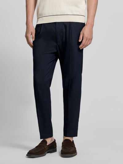 Männermodel trägt Hose mit Bügelfalte und elastischem Bund Modell 'CHASY' von Drykorn, Dunkelblau, Leinen-Mix mit Viskose-Anteil, Slim-Fit, Eingrifftaschen, Knopf-Reißverschluss, Ganzkörperansicht von vorne.