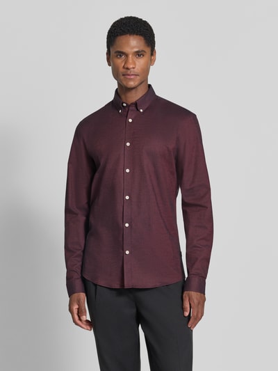 Męski model nosi Regular Fit Freizeithemd aus Baumwoll-Mix Modell 'Oxford' von Lindbergh, mieszanka bawełny i elastanu, kołnierzyk typu button down, mankiety zapinane na 1 guzik, zaokrąglony dół, długość tyłu w rozmiarze M: 77 cm, szerokość w rozmiarze M: 44 cm, długość rękawów w rozmiarze M: 66 cm, widok całej sylwetki z przodu.