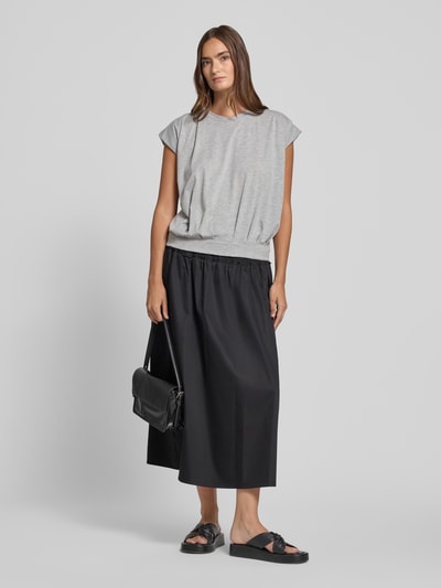 Frauenmodel trägt T-Shirt mit Rundhalsausschnitt und Kappärmeln von Christian Berg Woman aus Material-Mix mit Baumwoll-Anteil, Regular-Fit, graue Farbe, Drapierungen, kombiniert mit schwarzem Rock, Rückenlänge bei Größe S: 54 cm, Ganzkörperansicht von vorne.
