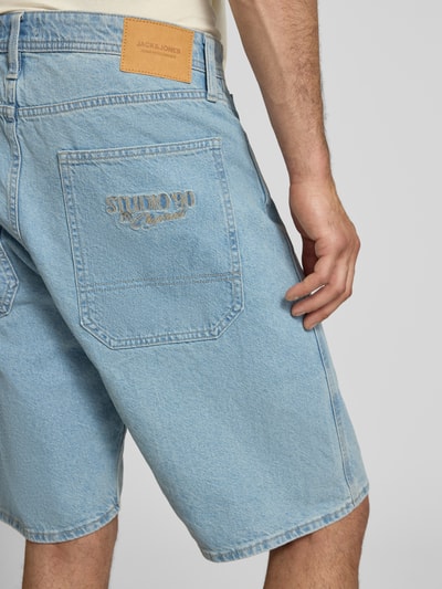 Männermodel trägt Jeansshorts im 5-Pocket-Design Modell 'ALEX' von Jack & Jones aus Reiner Baumwolle in Hellblau, Straight Fit, Bundweite 44 cm, Innenbeinlänge 30 cm, Knopf- und Reißverschluss, Ganzkörperansicht Rückansicht.