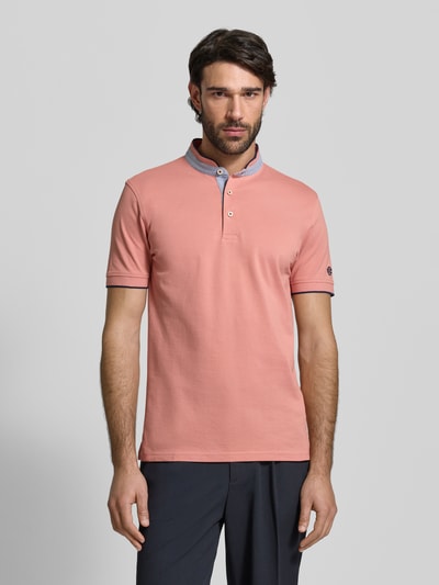 Männermodel trägt Regular Fit Poloshirt aus reiner Baumwolle mit Stehkragen von Christian Berg Men in Rosa mit blauen Details, Ganzkörperansicht von vorne.