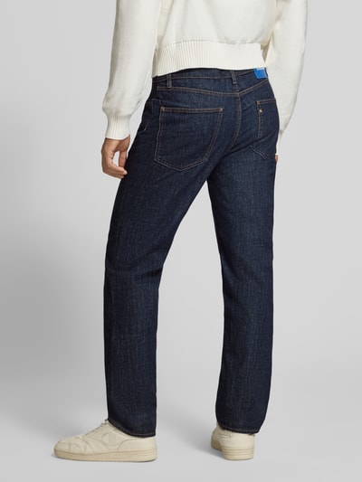 Männermodel trägt Straight Fit Jeans aus reiner Baumwolle Modell 'Jonah' von HUGO in Dunkelblau, strukturierte Oberfläche, Ganzkörperansicht Rückansicht, Herren Straight Fit Jeans von HUGO Blue.